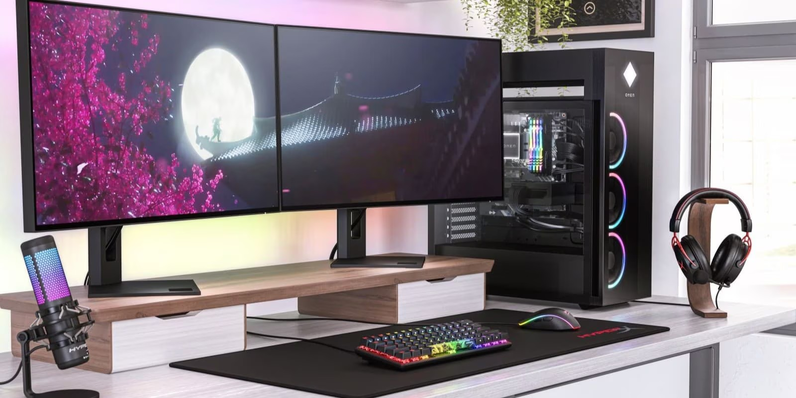 High-end gaming setup with dual monitors, RGB PC, mechanical keyboard, and streaming accessories